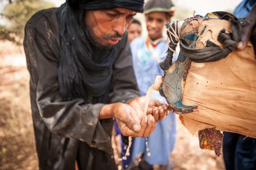 touareg recevant de l'eau dans ses mains